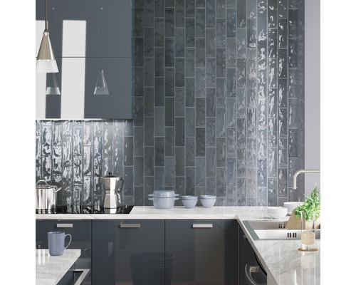 Moderne Küche mit grauen Schrankfronten, Arbeitsplatte aus Stein und Wandfliesen