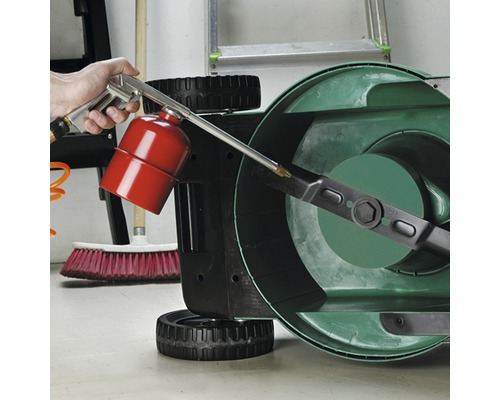 Eine Person reinigt ein Rasenmähermesser mit einer Reinigungspistole