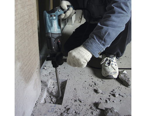 Ein Mann verwendet einen Bohrhammer von Makita zum Stemmen von Beton.