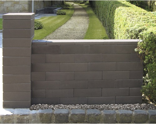 Mauer aus Betonsteinen mit Säule und Kies im Garten
