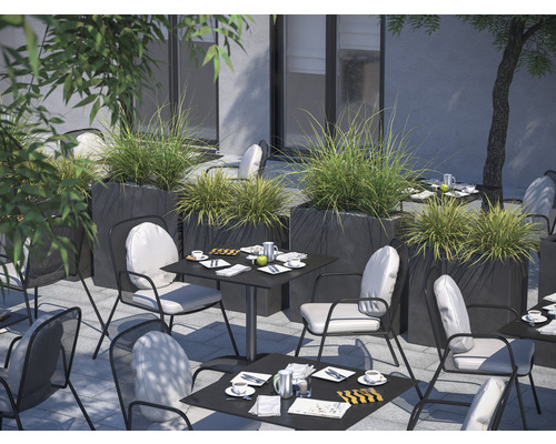 Außenbereich mit Tischen, Stühlen und Pflanzgefäßen