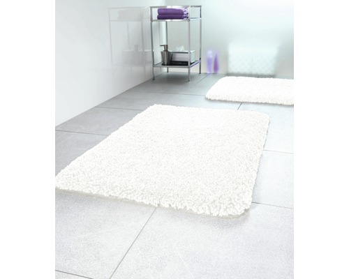 Badezimmer mit zwei weißen Badteppichen und einem Regal
