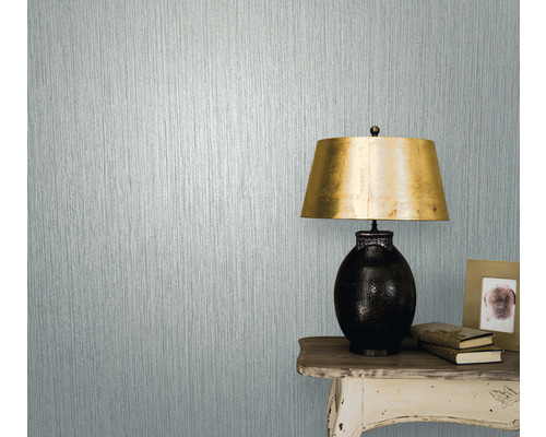 Nahaufnahme einer Wand mit Strukturtapete neben einem Tisch mit Lampe