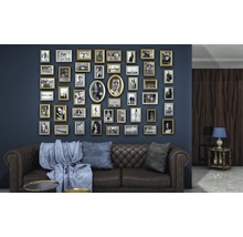 Wohnzimmer mit braunem Sofa, blauer Wand und vielen Bilderrahmen