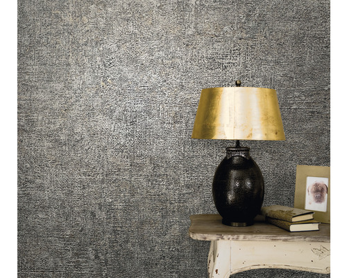 Detailaufnahme einer gemusterten Tapete an der Wand, die neben einem Tisch mit einer Lampe und Dekorationen angebracht ist