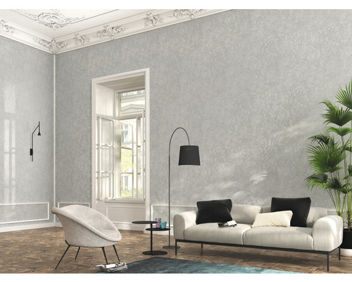 Wohnzimmer mit grauer Mustertapete, Sofa, Sessel und Zimmerpflanze