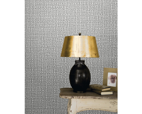 Nahaufnahme einer silberfarbenen Textiltapete imitiert Textilstruktur mit einer Lampe auf einem Tisch