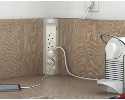 Ecksteckdose mit eingesteckten Geräten auf einer Arbeitsfläche