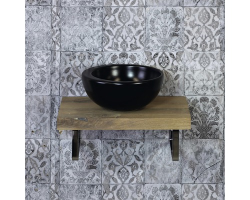 Schwarzes Aufsatzwaschbecken auf Holzablage mit Wandfliesen im Hintergrund