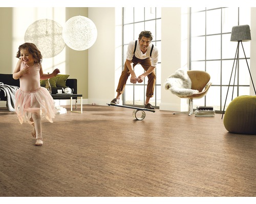 Helles Wohnzimmer mit Korkboden, in dem ein Mann auf einem Balance Board steht und ein Mädchen tanzt