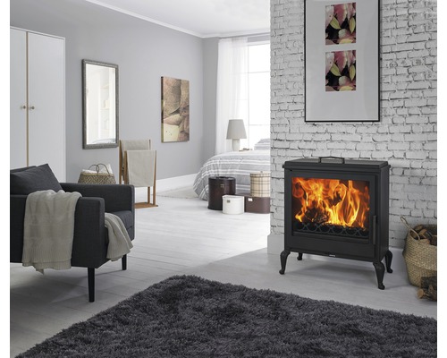 Wohnzimmer mit Kaminofen, Sessel und Teppich