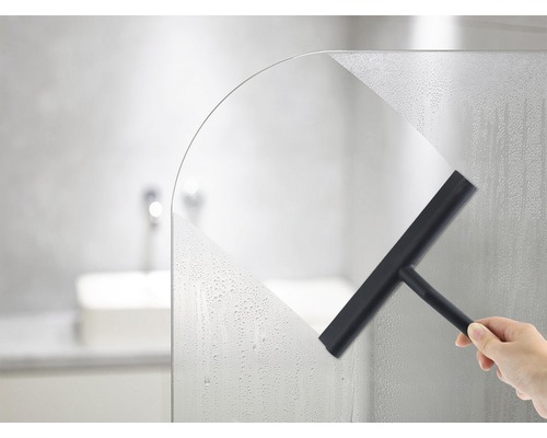 Hand wischt mit einem Abzieher eine Duschwand trocken