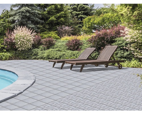 Garten mit Pflastersteinen, Pool und zwei Liegestühlen