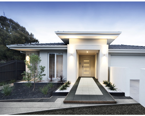 Einfamilienhaus mit gepflastertem Weg zum Eingangsbereich und gepflegtem Vorgarten