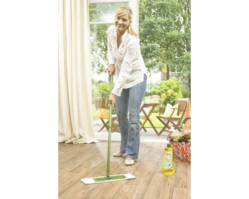 Frau wischt Holzboden mit Mopp und Reinigungsmittel