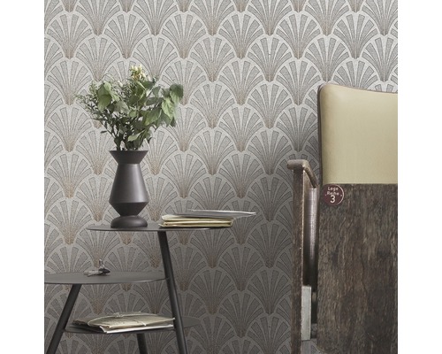 Nahaufnahme einer Wand mit einer Tapete mit fächerförmigem Muster in einem Raum mit Tisch und Stuhl