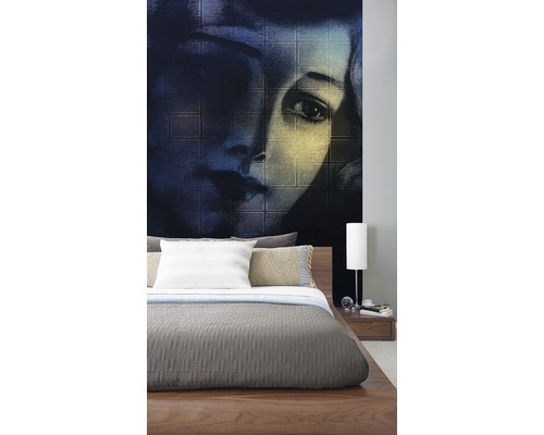 Schlafzimmer mit Fototapete eines Frauengesichts hinter einem Holzbett.
