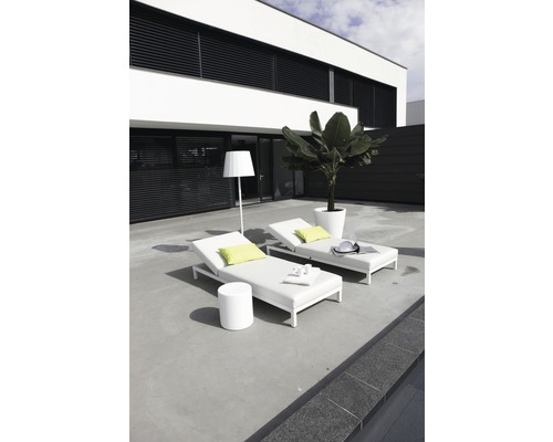 Zwei weiße Gartenliegen mit Tisch und Stehlampe auf einer Terrasse