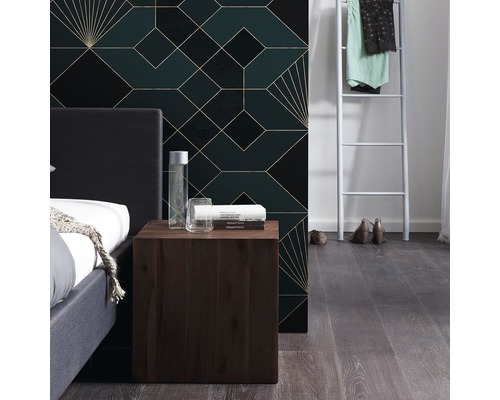 Schlafzimmer mit Bett, Nachttisch und geometrischer Tapete