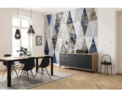 Wohnraum mit Esstisch, Stühlen, Sideboard und Tapete mit geometrischem Muster