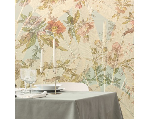 Gedeckter Esstisch vor einer floral gemusterten Tapete mit Blattmotiven.