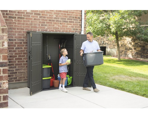 Mann und Kind vor Gerätehaus mit Gartengeräten