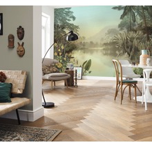 Wohnraum mit tropischer Fototapete, Holzboden im Fischgrätmuster, Sitzmöbeln und Stehlampe.