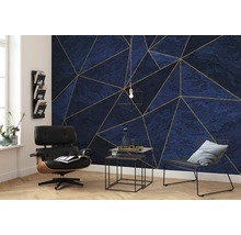 Wohnzimmer mit blau-goldener geometrischer Mustertapete, Sessel und Beistelltischen.