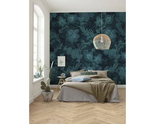 Schlafzimmer mit floraler Tapete, Bett und Holzboden in Fischgrätmuster