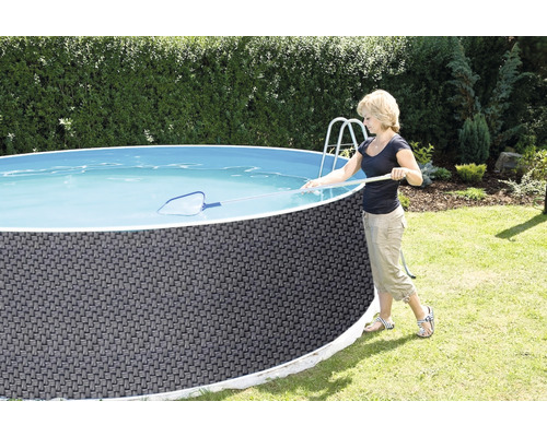 Frau reinigt einen runden Aufstellpool mit einem Kescher im Garten.
