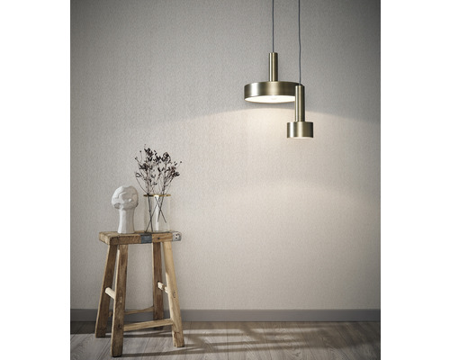 Innenraumszene mit Pendelleuchte, Hocker, Vase mit Trockenblumen und einer Skulptur