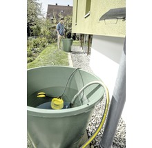 Regenwassernutzungssystem mit Regentonne, Tauchpumpe und Person im Garten