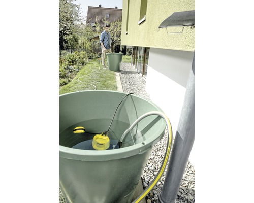 Regenwassernutzungssystem mit Regentonne, Tauchpumpe und Person im Garten