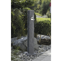 Gartenszene mit einer Wasserzapfsäule aus Stein mit einem Wasserhahn aus Metall.