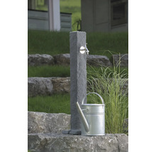 Gartenszene mit Wasserentnahmestelle aus Stein und Gießkanne