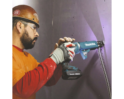 Handwerker verwendet Makita Magazinschrauber an Wand