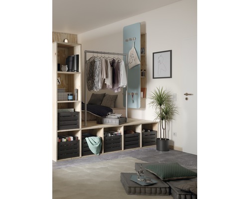 Wohnzimmer mit Stauraumlösung aus Regalen, Kleiderstange und dekorativen Elementen.