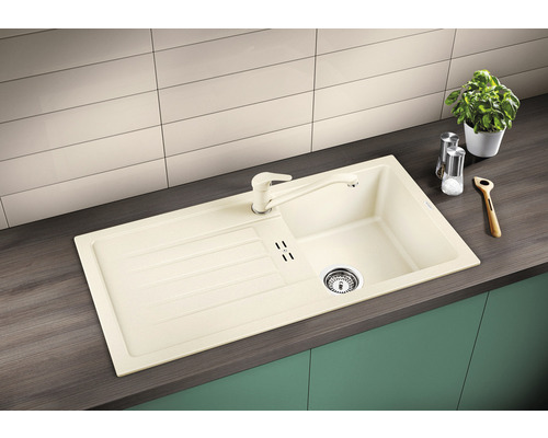 Spüle aus Verbundwerkstoff mit Abtropffläche und passender Armatur in einer Küchenumgebung.