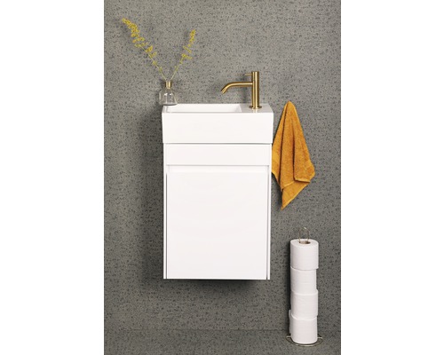Weißer Waschbeckenunterschrank mit Armatur, Handtuch und Toilettenpapierhalter