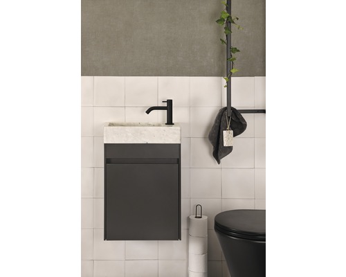 Badezimmer mit Waschbeckenunterschrank, Armatur, Handtuch und Toilette