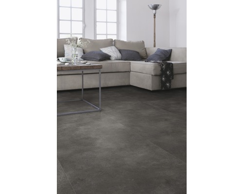 Wohnzimmer mit grauer Bodenfläche, Sofa und Beistelltisch.