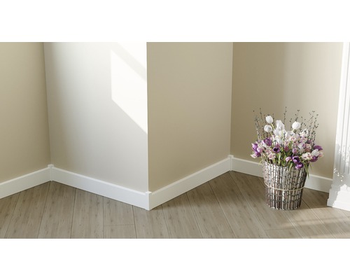 Raumecke mit weißen Sockelleisten und Blumenarrangement