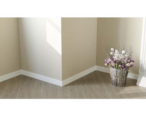 Helle Raumecke mit Laminatboden, weißen Sockelleisten und Blumenarrangement