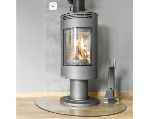 Kaminofen mit Holzscheiten, Glasbodenplatte und Kaminbesteck