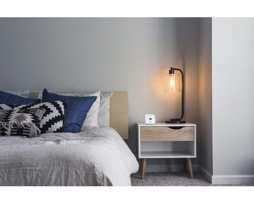 Schlafzimmer mit Bett, Nachttisch und Lampe im modernen Stil.