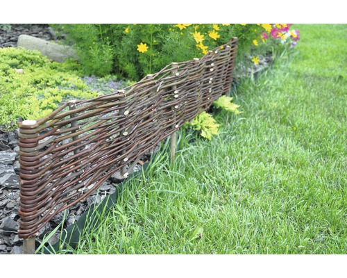 Gartenszene mit einem niedrigen Zaun aus geflochtenen Ästen