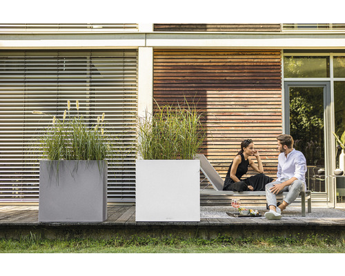 Zwei Pflanzgefäße mit Ziergras im Außenbereich und entspanntes Paar