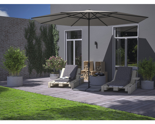 Terrasse mit Sonnenschirm, Liegestühlen, Holzkisten und Dekoration