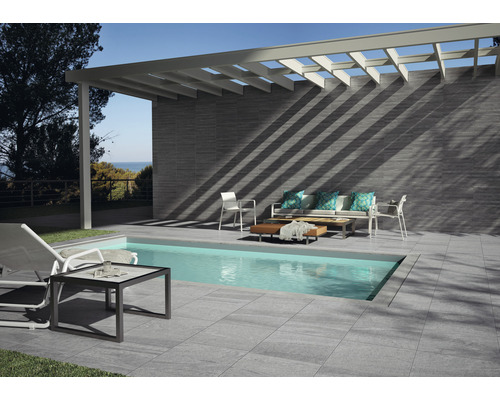 Außenbereich mit Pool, Fliesenboden, Fliesenwand, Pergola und Gartenmöbeln.