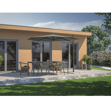 Terrassenszene mit Esstisch, Stühlen und Sonnenschirm vor einem Gebäude